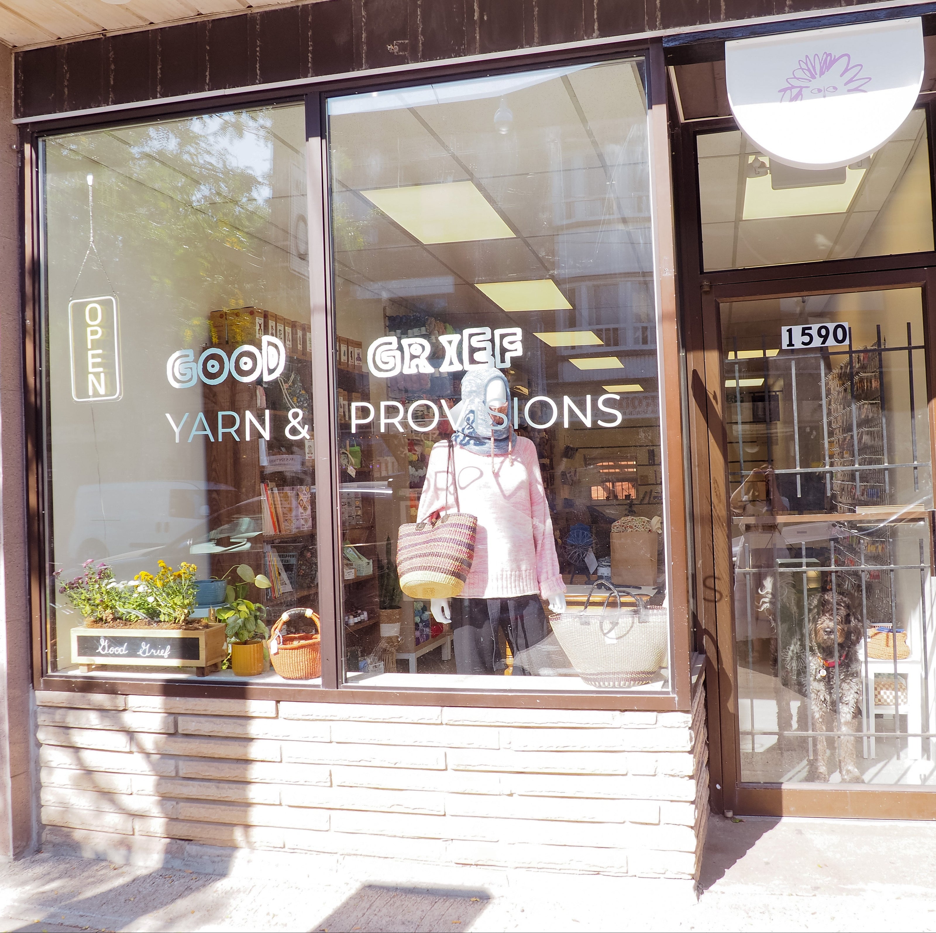 Storefront with 'Good Yarn & Grief Provisions' sign on glass window