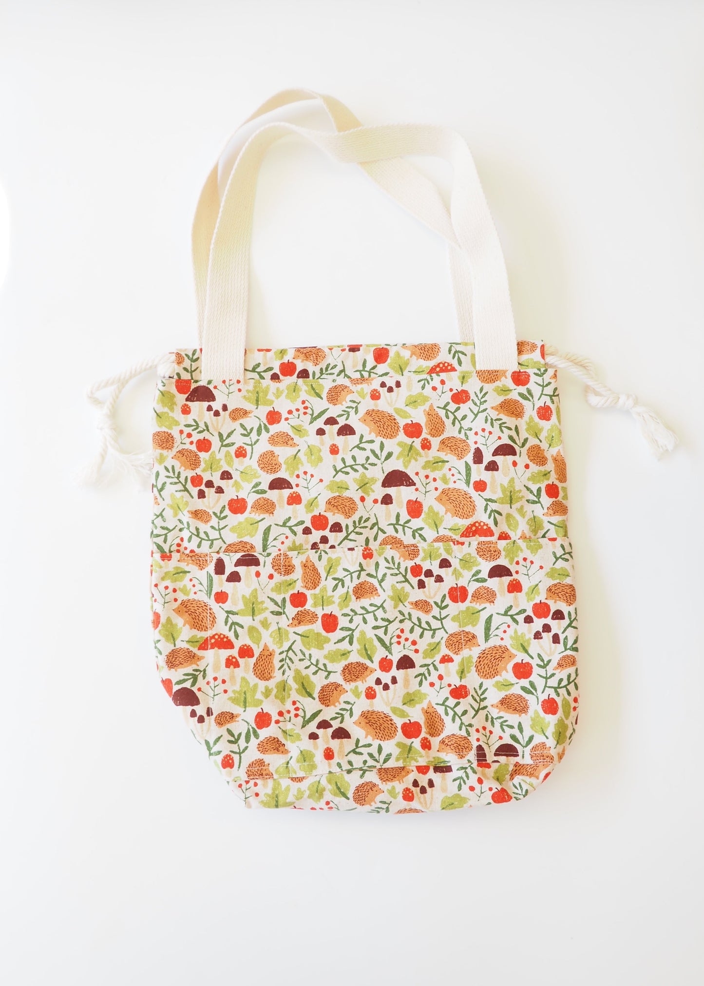 Floral-patterned tote bag on a white surface with a wooden background
