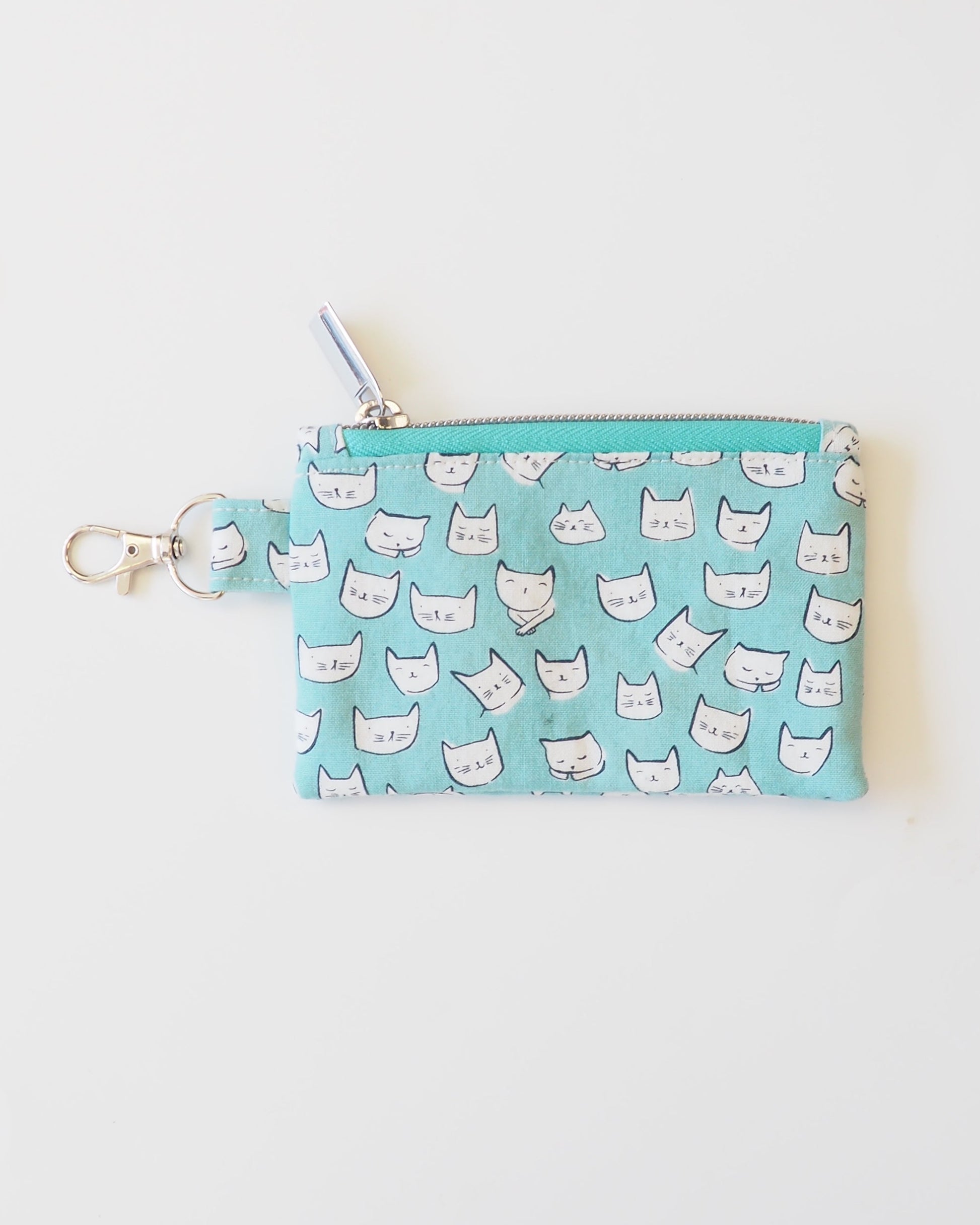 Small blue pouch with white cat pattern on a light gray background