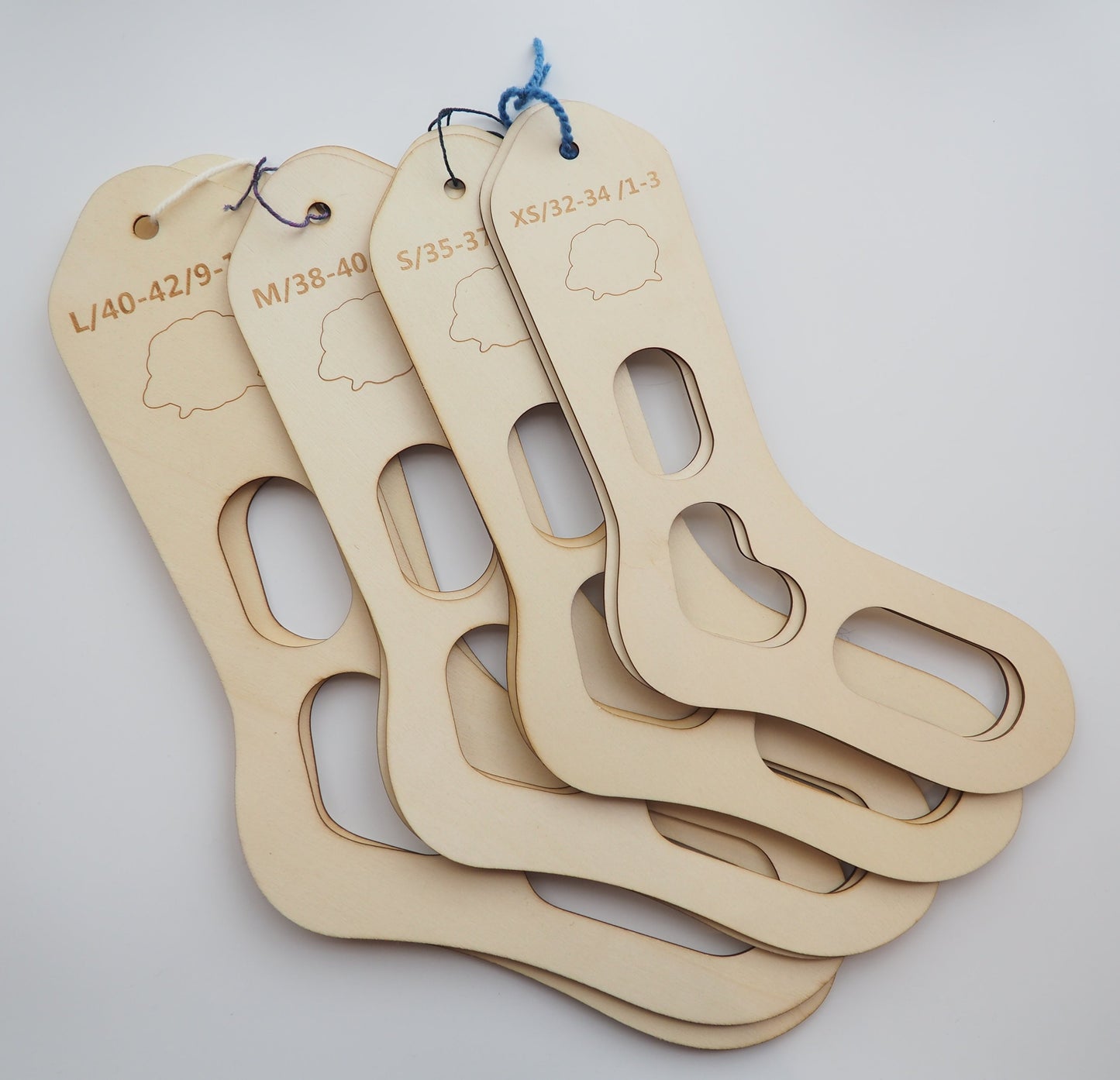 image of 4 sets of wooden sock blockers in sizes extras small, small, medium, and large. 