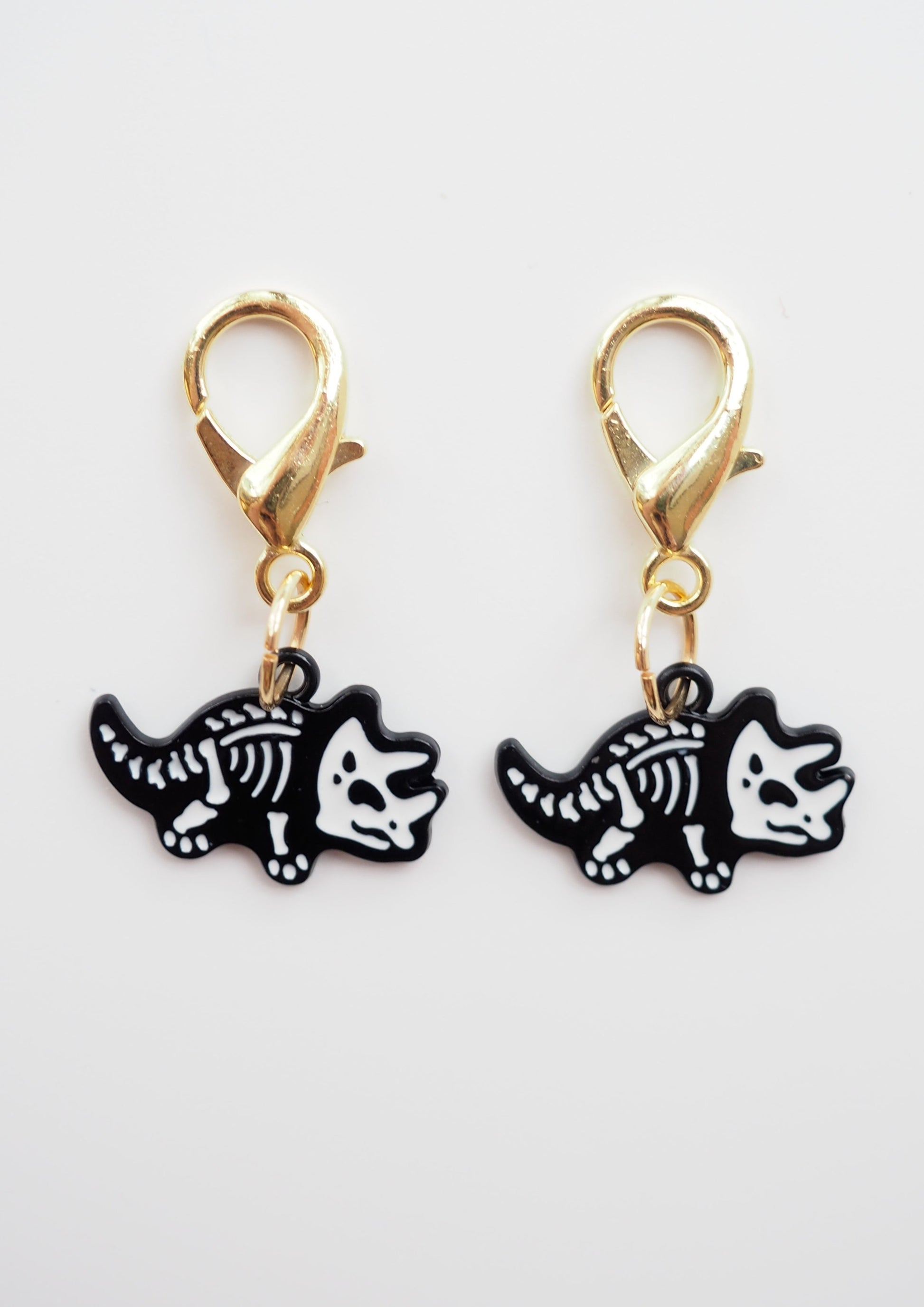 Set of 2 skeleton dinosaur stitch markers for knitting and crochet projects. Playful accessories from Good Grief Toronto.