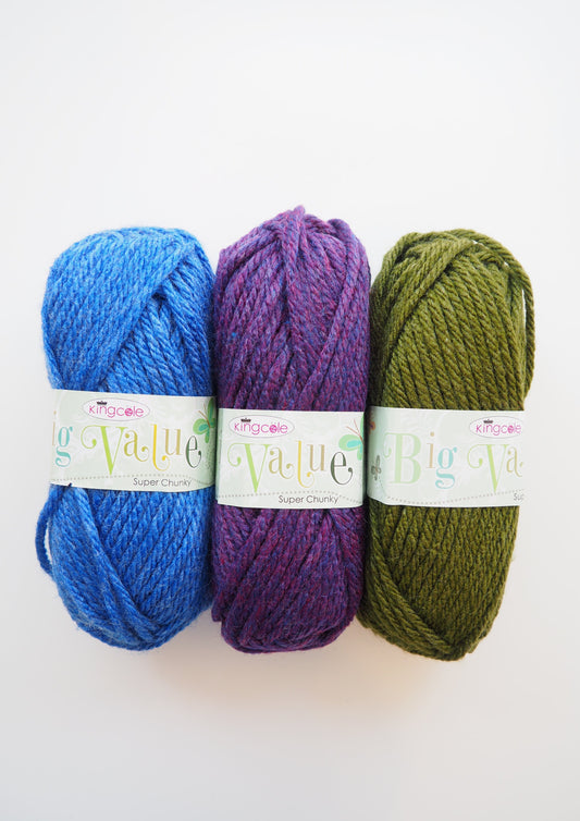 Three balls of King Cole Yarns Big Value Chunky: one in a vibrant blue color, another in a lovely green shade, and the third in a captivating purple hue.