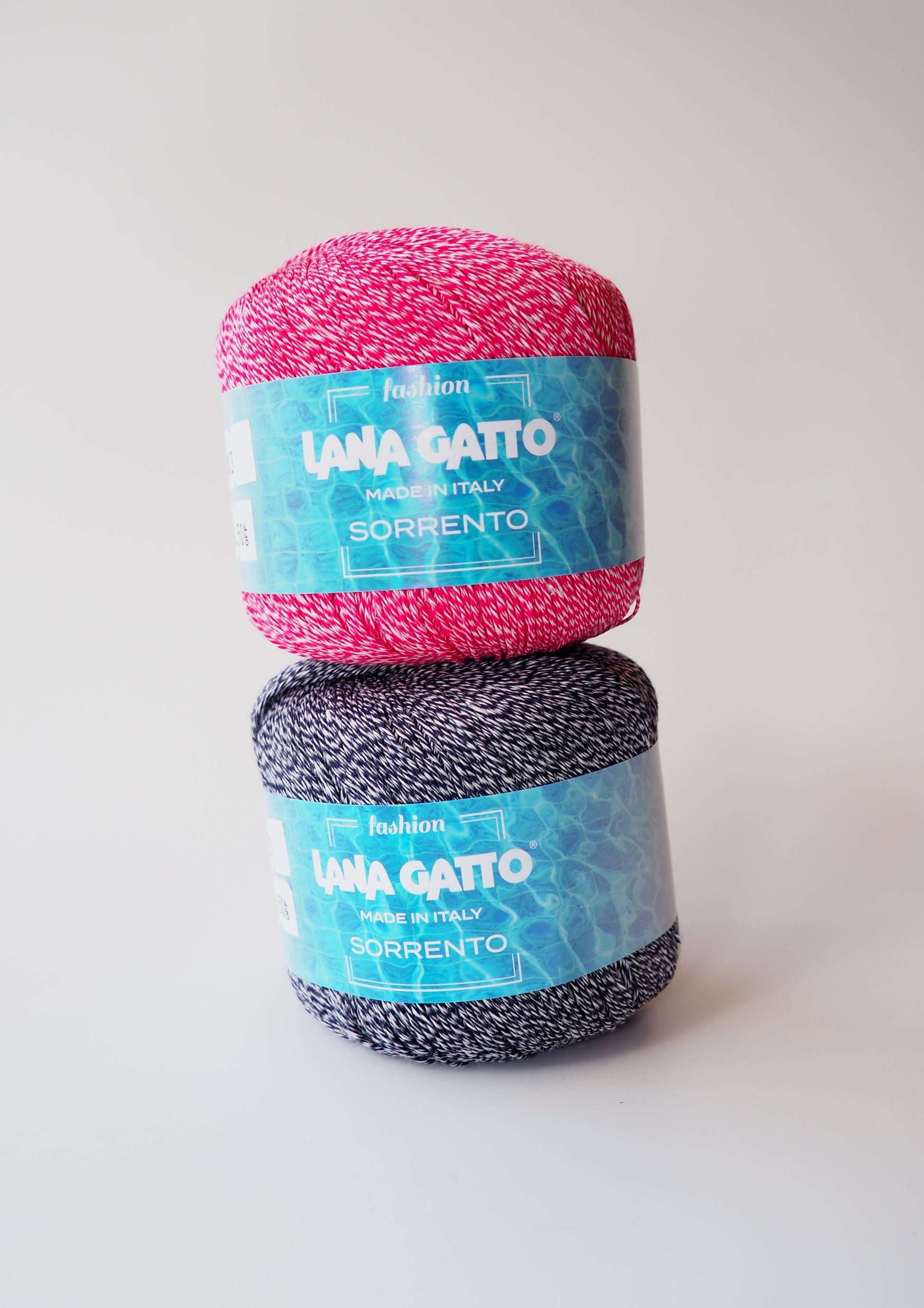 Image of Lana Gatto Sorrento yarn: Two balls, one in red color and one in black color, showcasing the beautiful texture and color options.